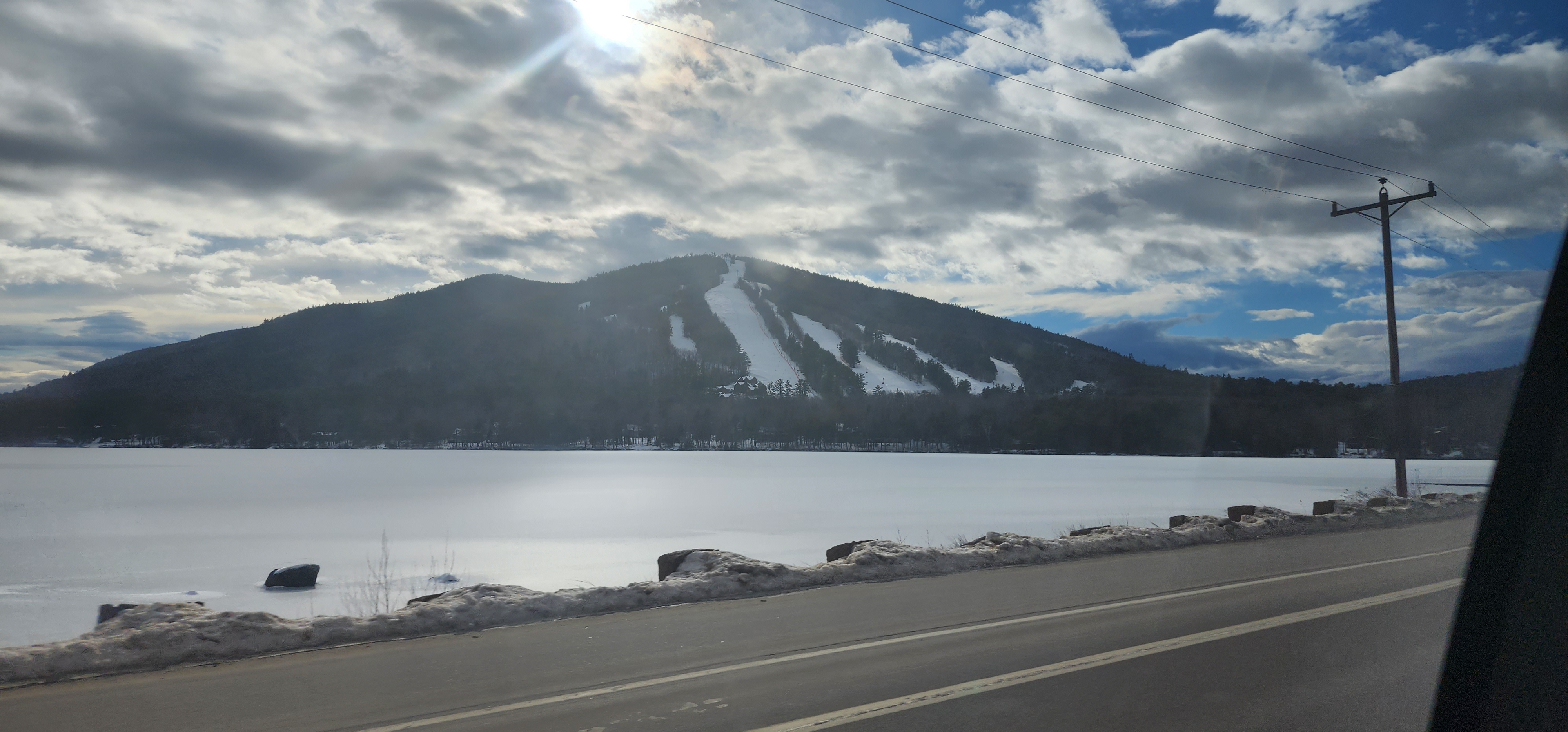 A snow-covered ski mountain viewed across a frozen lake during the PTA Snowsports program