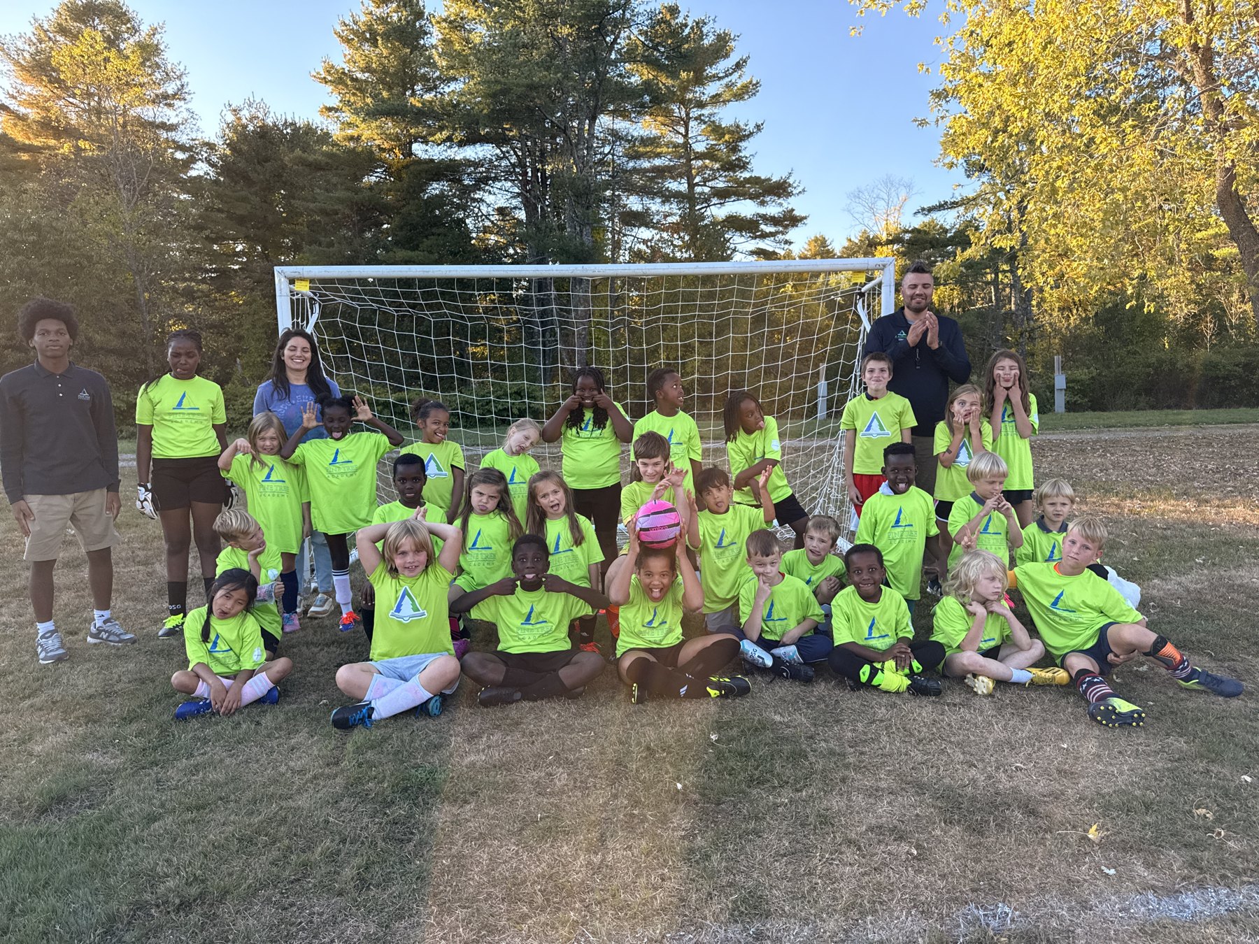 Pine Tree Academy Littles soccer players and coaches gathered together in front of the goal