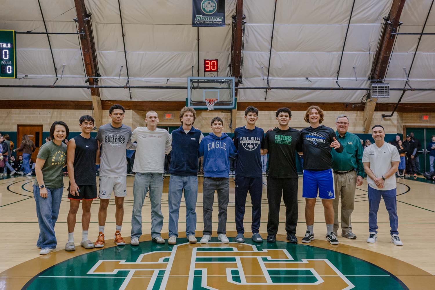 All-Tournament Team players and tournament officials standing at center court at the Pacific Union College Pioneers Invitational
