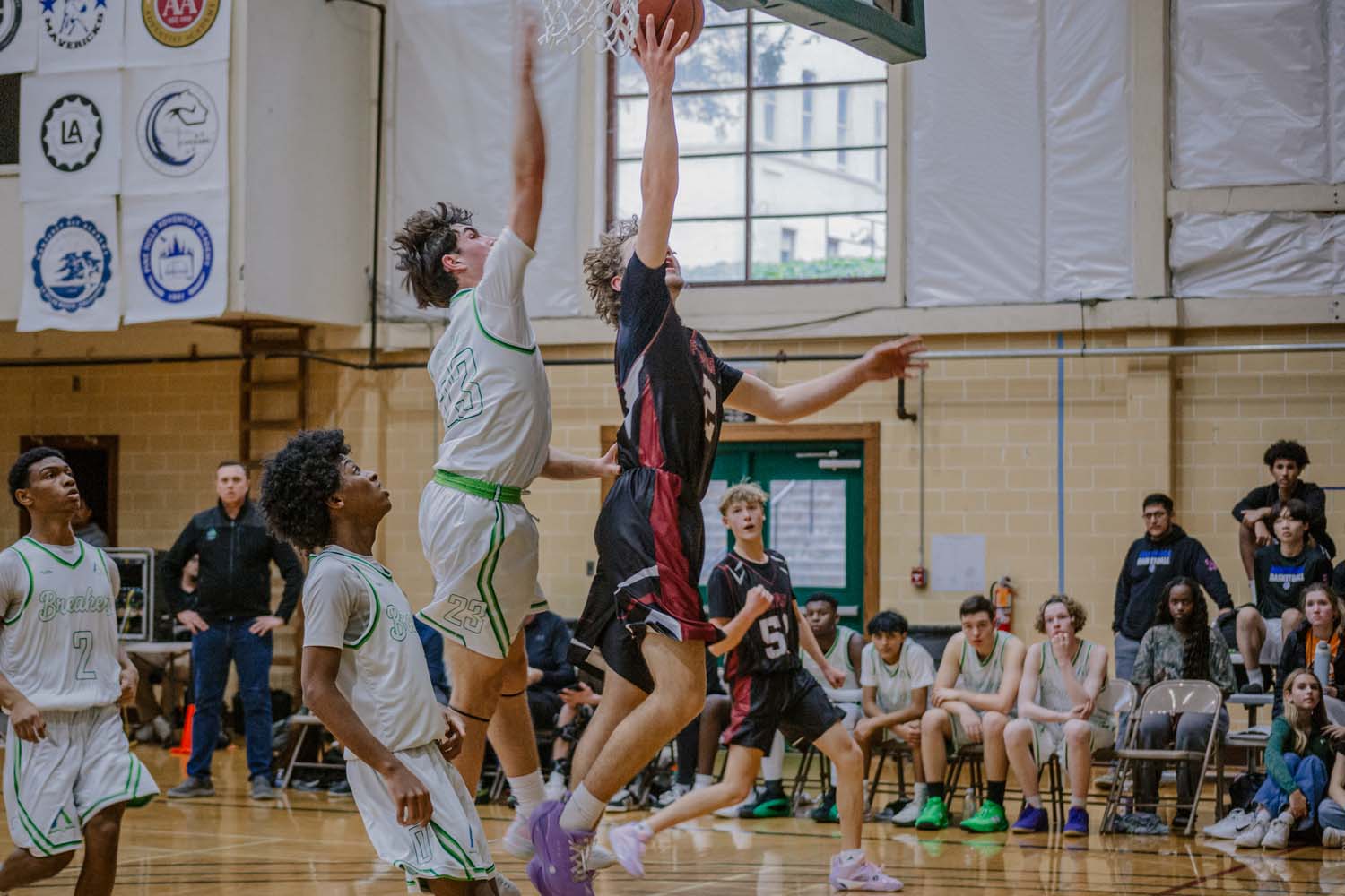 Pine Tree Academy boys varsity basketball player in a white uniform contesting a shot at the rim