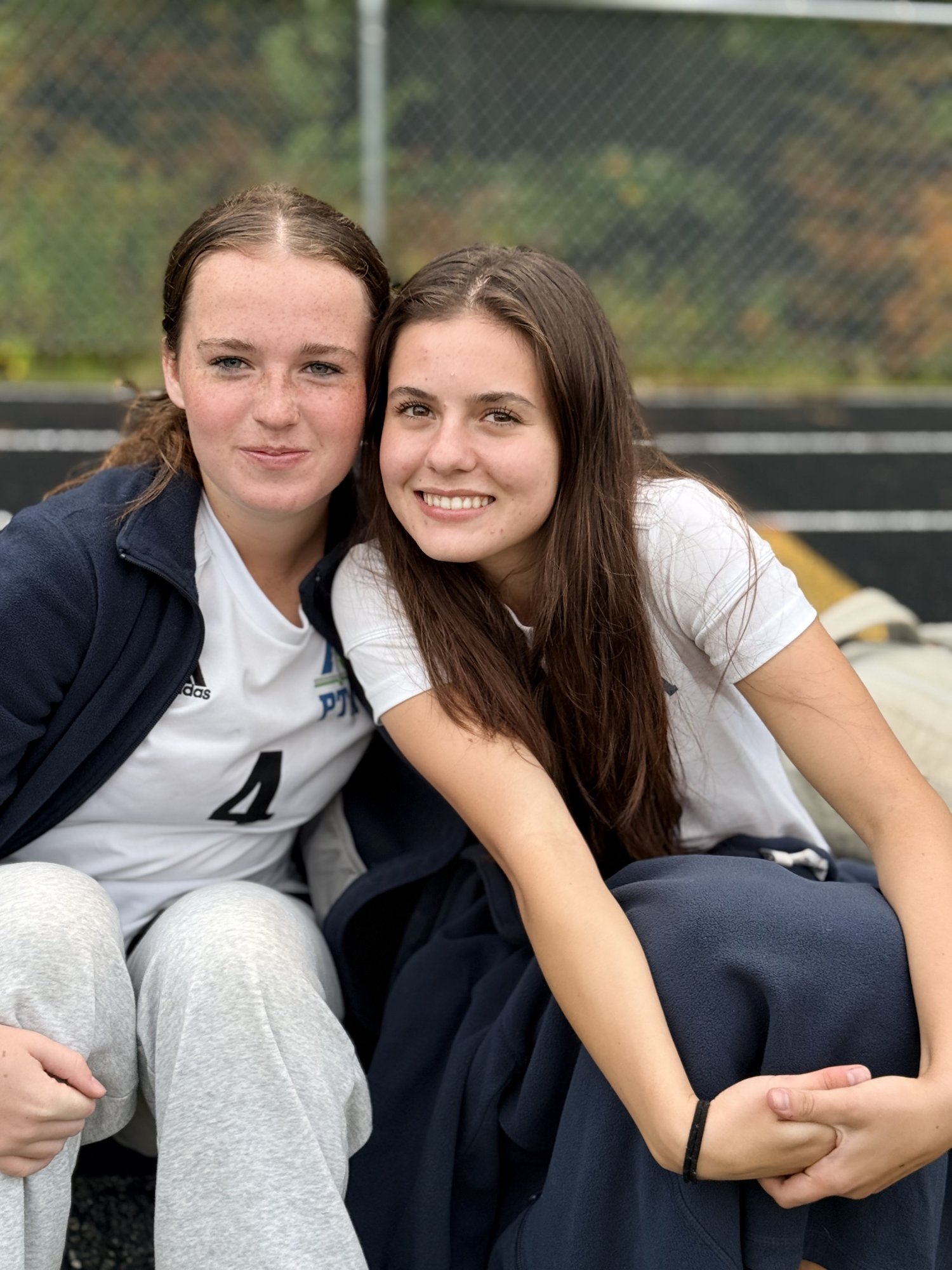 Two smiling Pine Tree Academy soccer players sitting together on the sideline during the 6-0 road win at Wiscasset/Boothbay on September 29, 2026