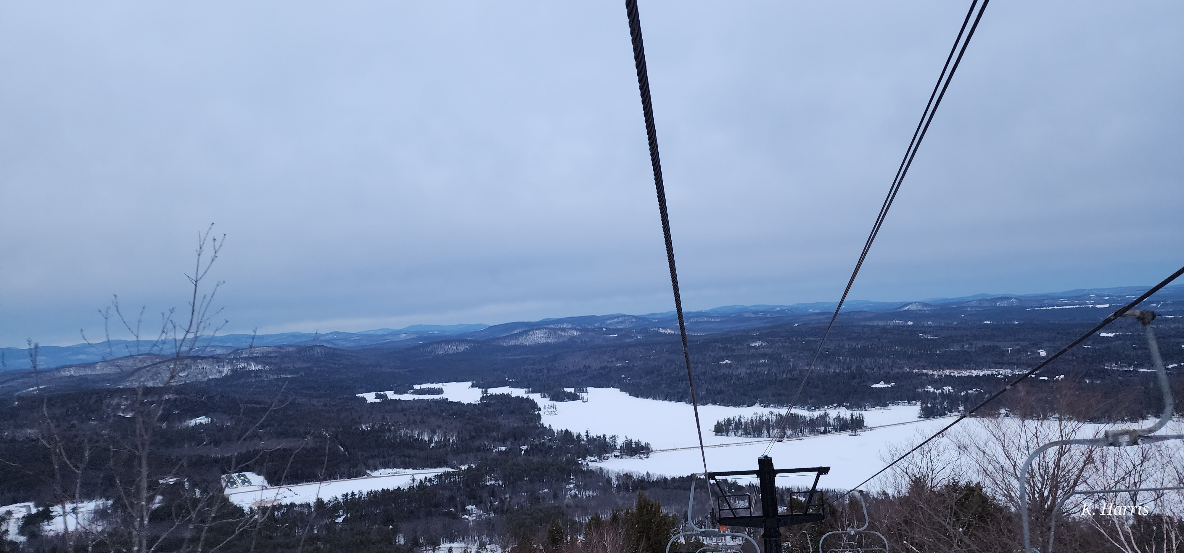 A snowy mountain and lake landscape viewed from a chairlift during the PTA Snowsports program