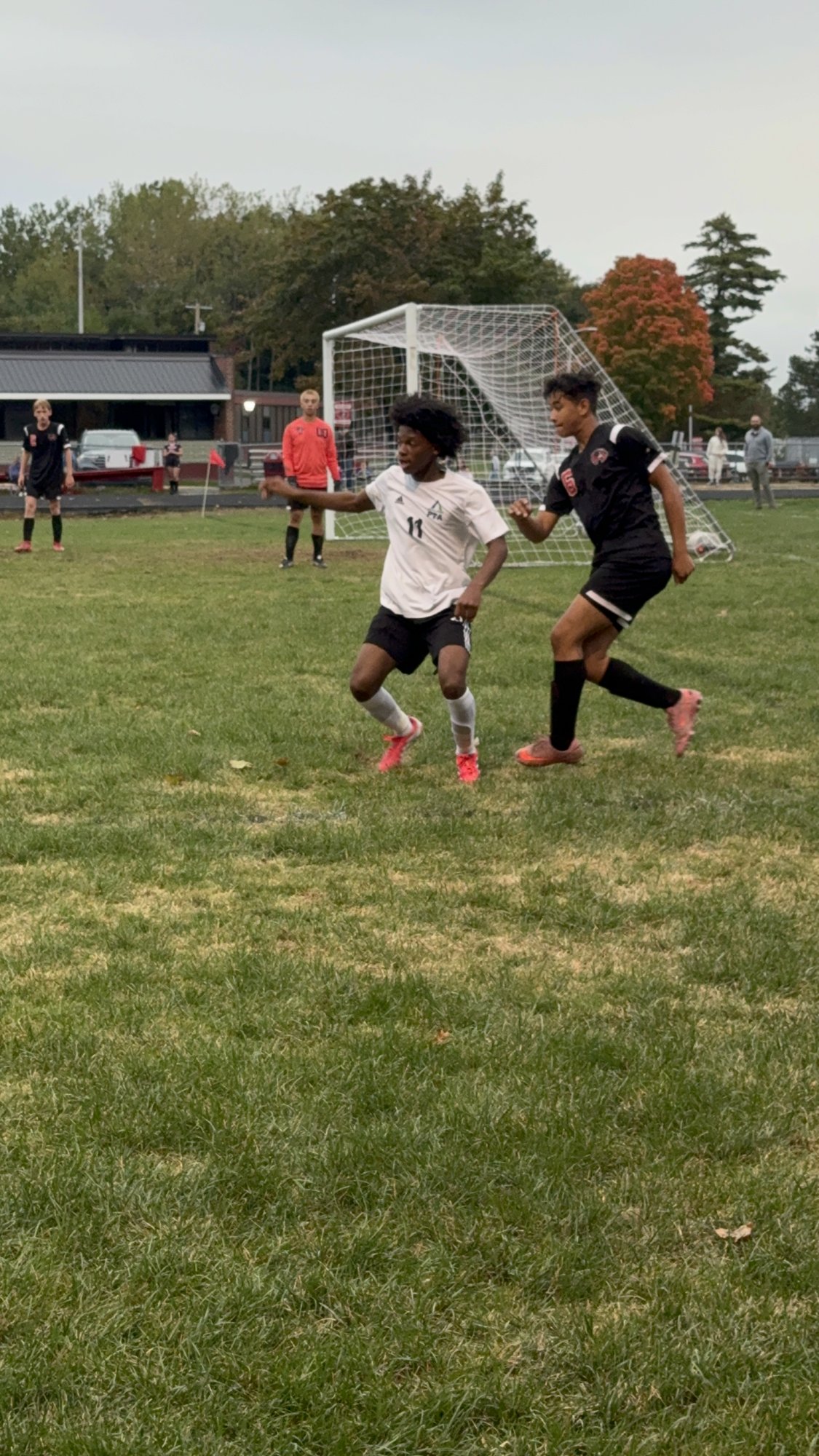 Pine Tree Academy boys varsity soccer player battling a Wiscasset/Boothbay defender near the goal during the 6-0 road win at Wiscasset/Boothbay on September 29, 2026