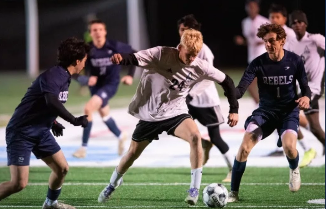 Collin Verrill in Pine Tree Academy's white number 21 jersey battling Telstar defenders during the November 2025 South regional final