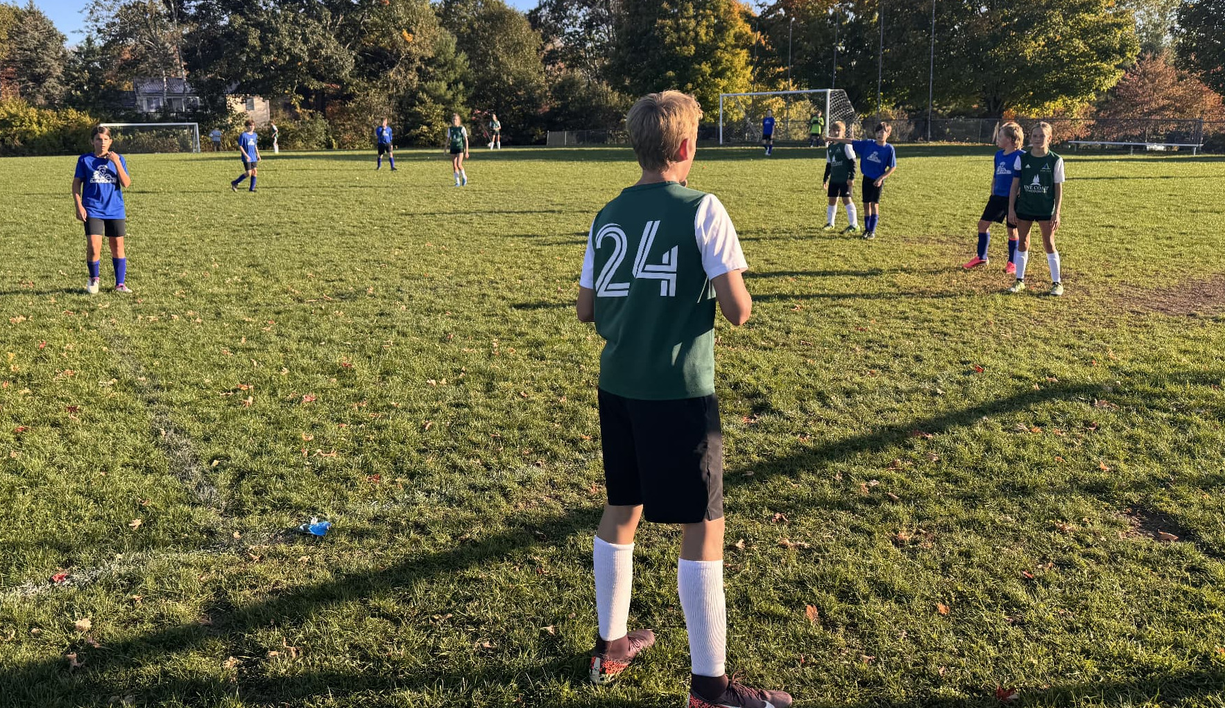 Action photo from Pine Tree Academy middle school soccer's 6–2 road victory over Seacoast Christian School on October 7, 2026, with a player in the foreground watching play develop toward goal