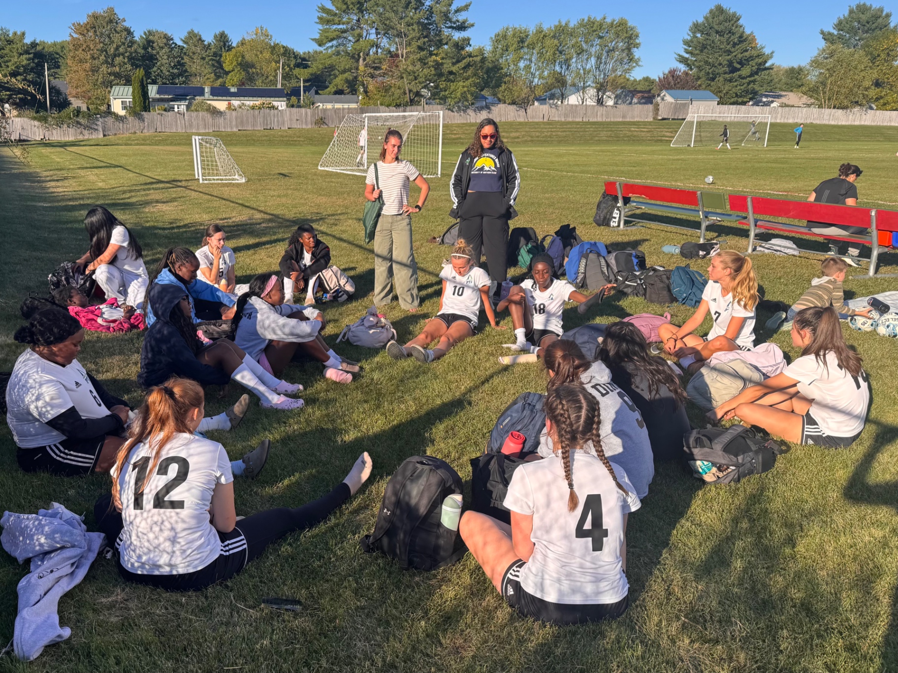 Pine Tree Academy girls varsity soccer players and coaches gathered on the sideline before the September 22, 2026 neutral-site match against Temple Academy at Capital Area Sports Complex in Augusta