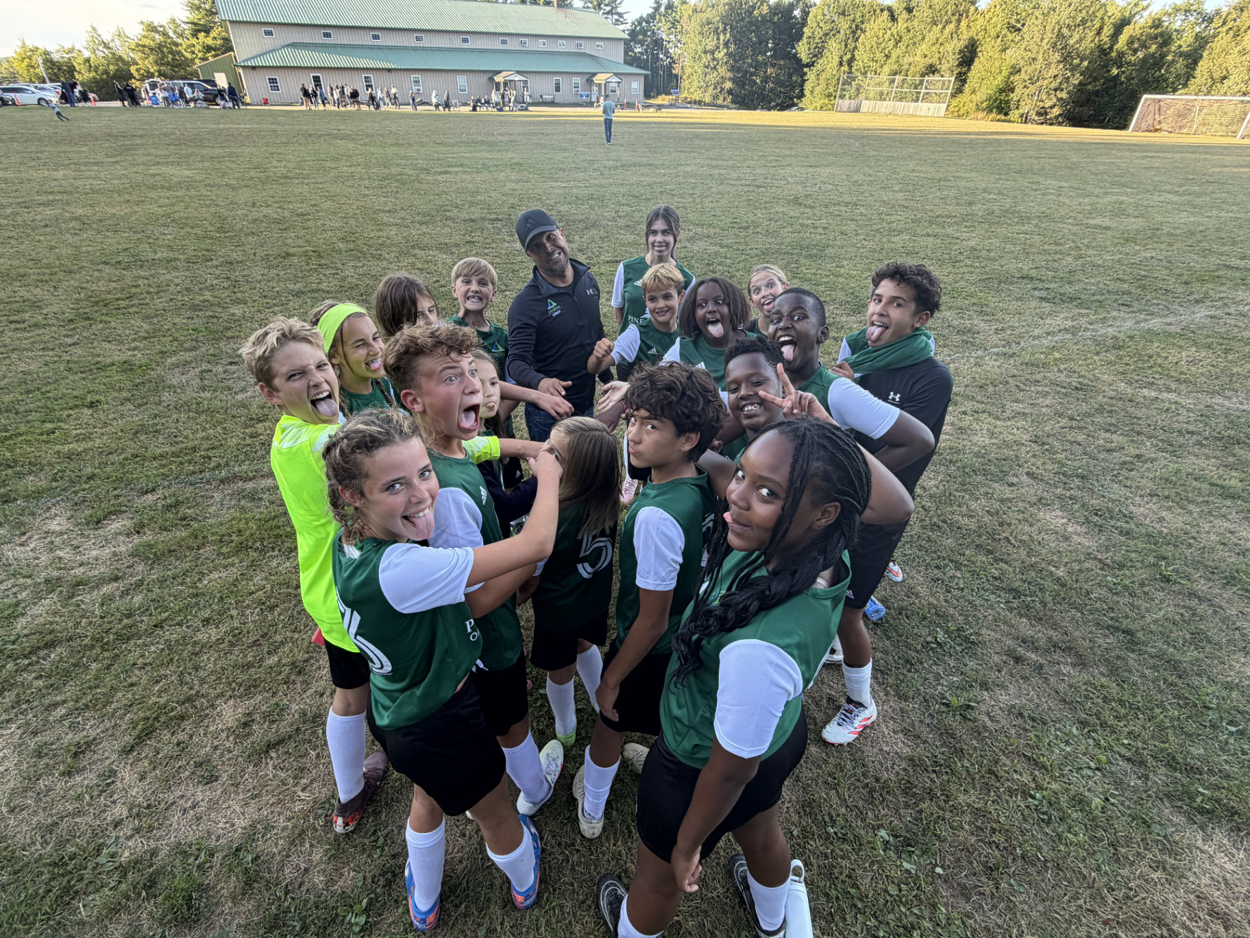 Pine Tree Academy middle school soccer players celebrating together on the field after the 5-2 season-opening win at Coastal Christian School